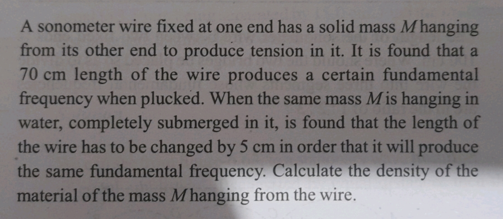 A sonometer wire fixed at one end has a solid mass M hanging from its 