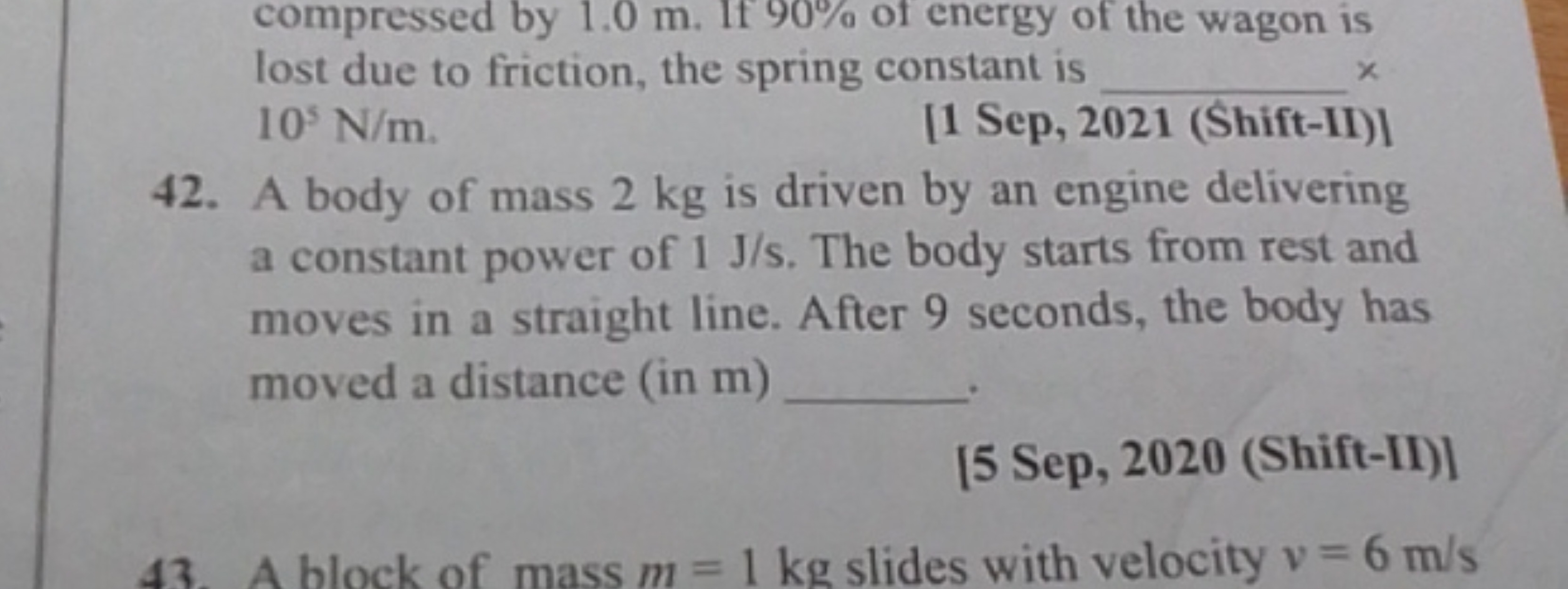 compressed by 1.0 m. If 90% of energy of the wagon is lost due to fric