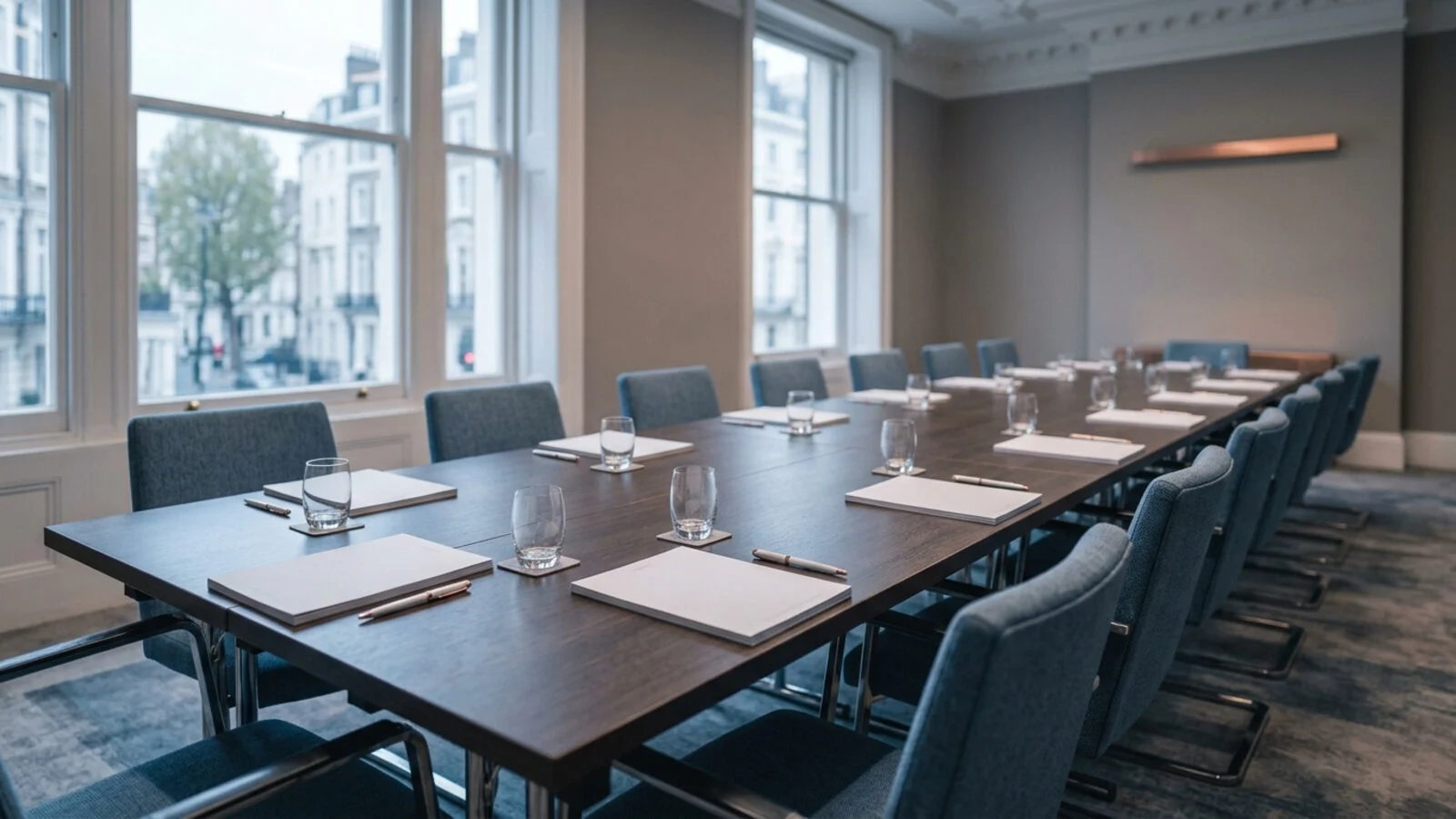 A long boardroom table set with paper agendas