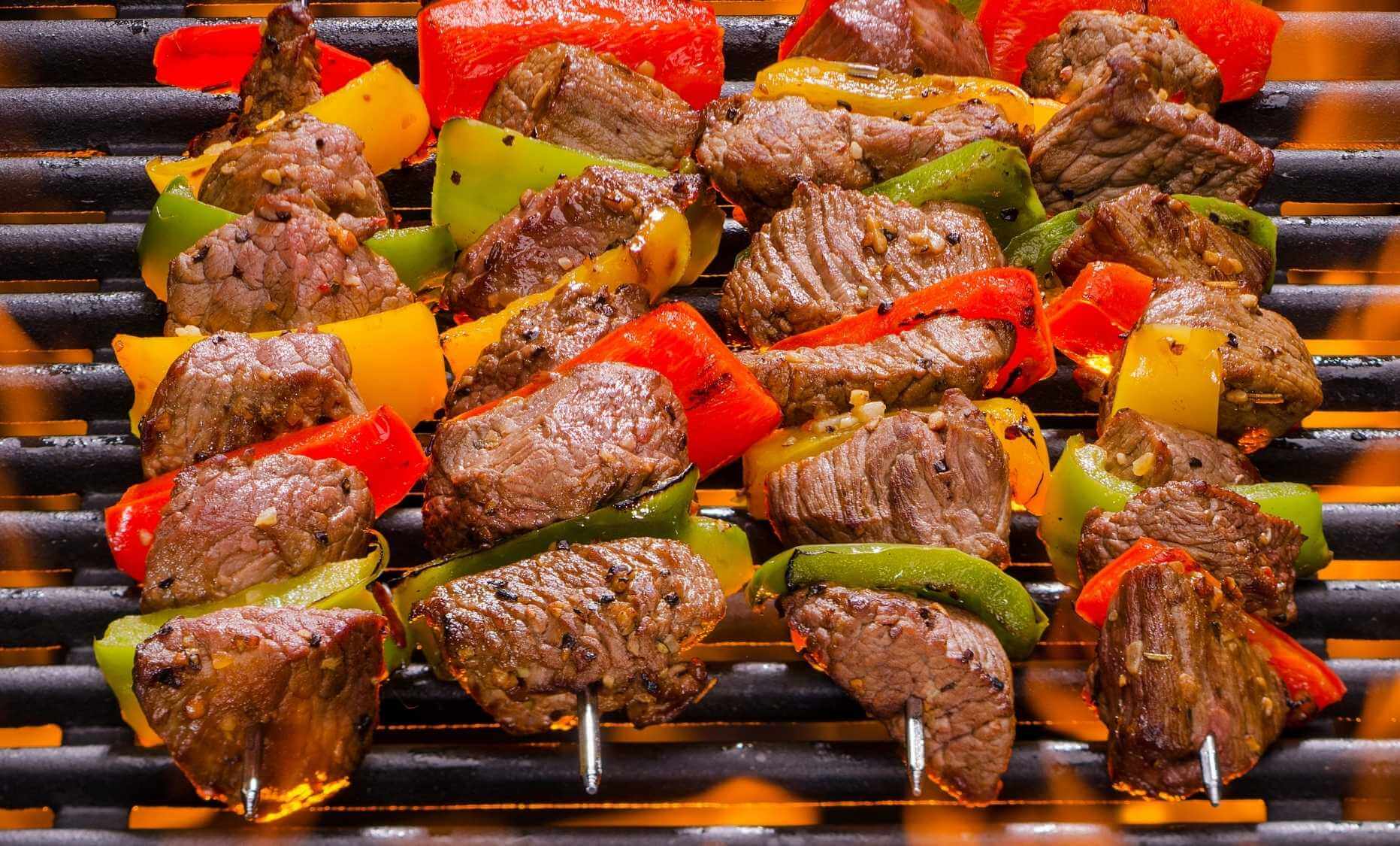 Carne en brochetas sobre un fuego