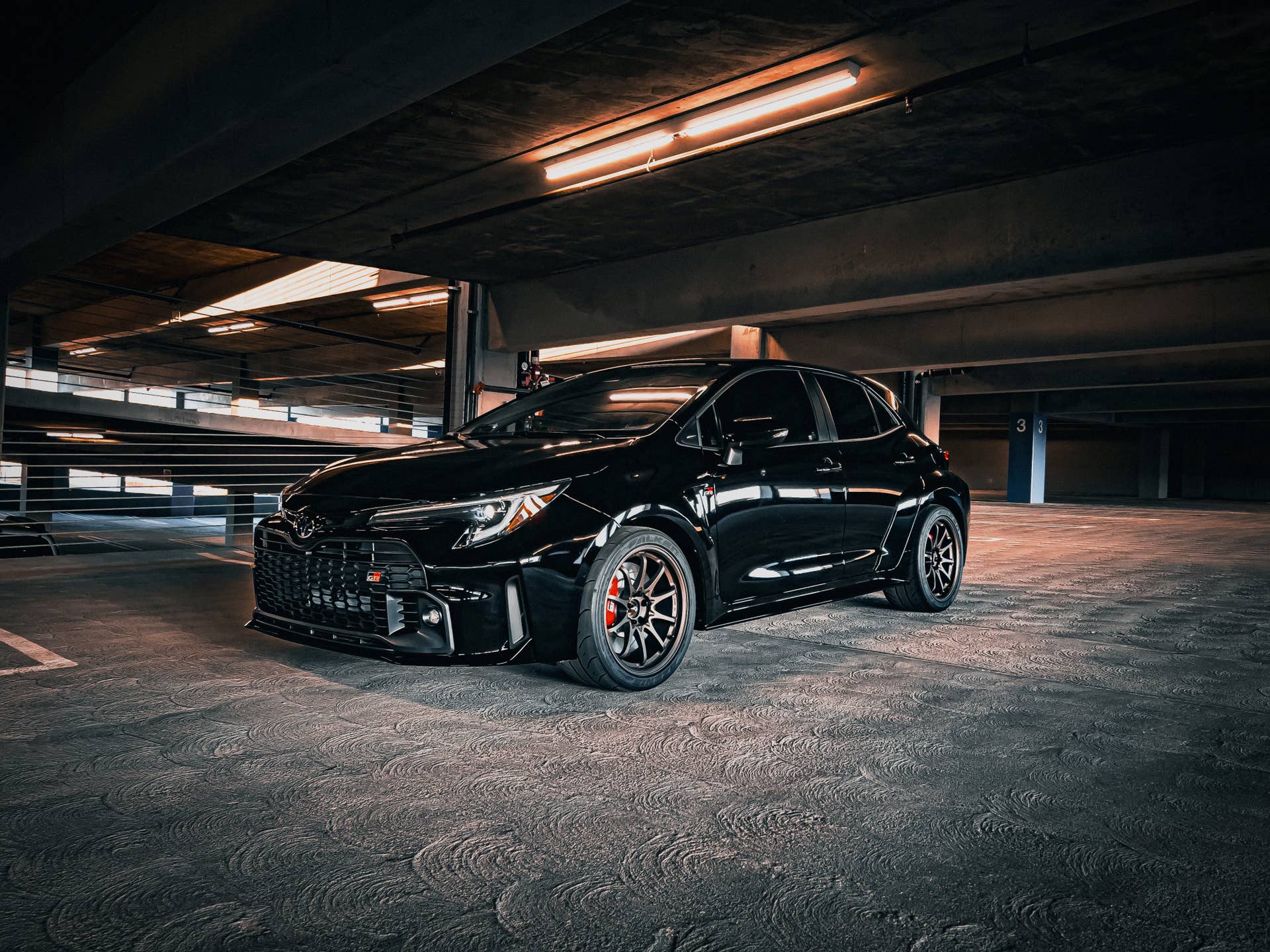 Black Toyota Corolla on Volk Racing CE28SL wheels in a parking garage