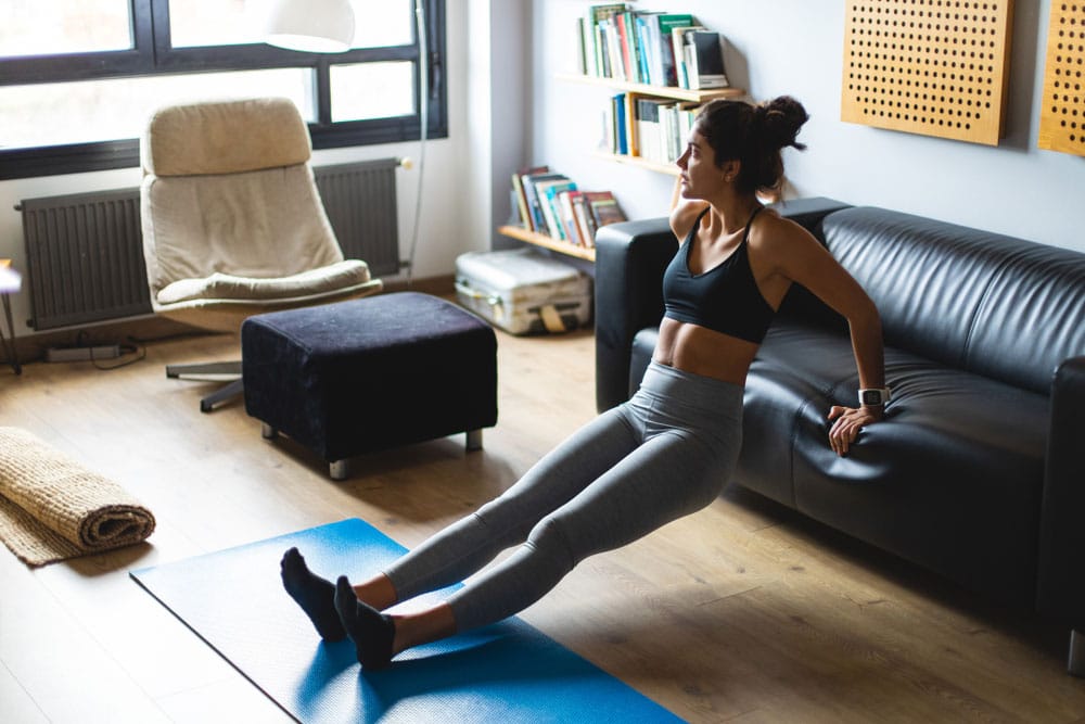 Woman performing dips off the edge of a couch