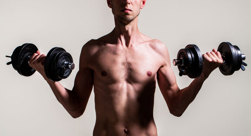 Slim man holding dumbbells