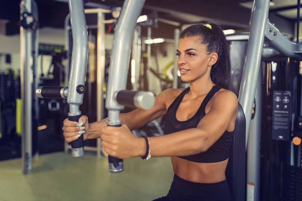 Woman training on a pec deck machine