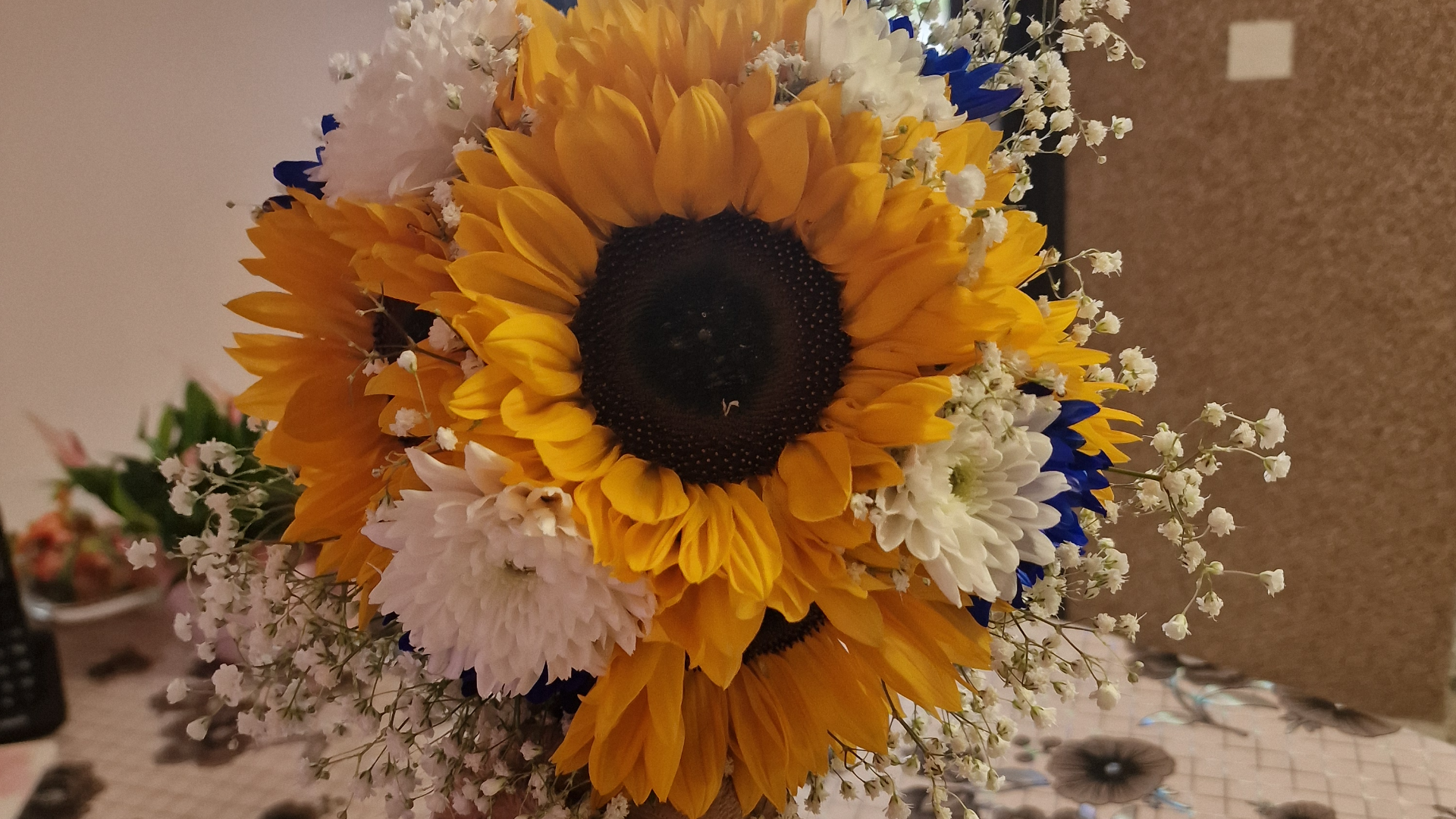 Ein bunter Blumenstaruß in einer Vase auf einem Tisch.