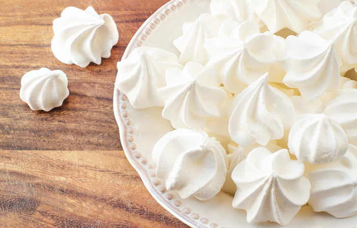 Porcelain plate full of many fluffy white meringue