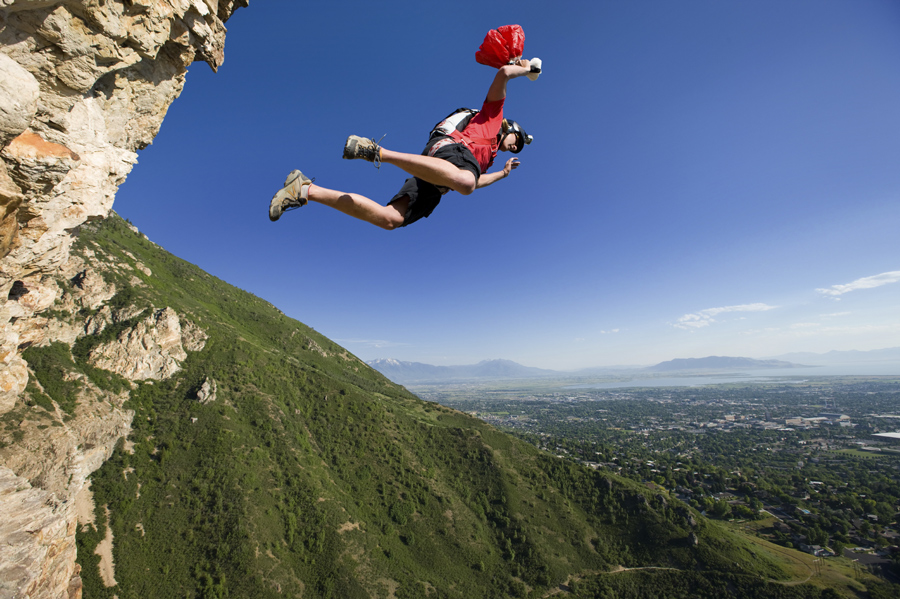 A BASE Jumper holding on to his pilot 'chute prior to a jump - Photo: iStock