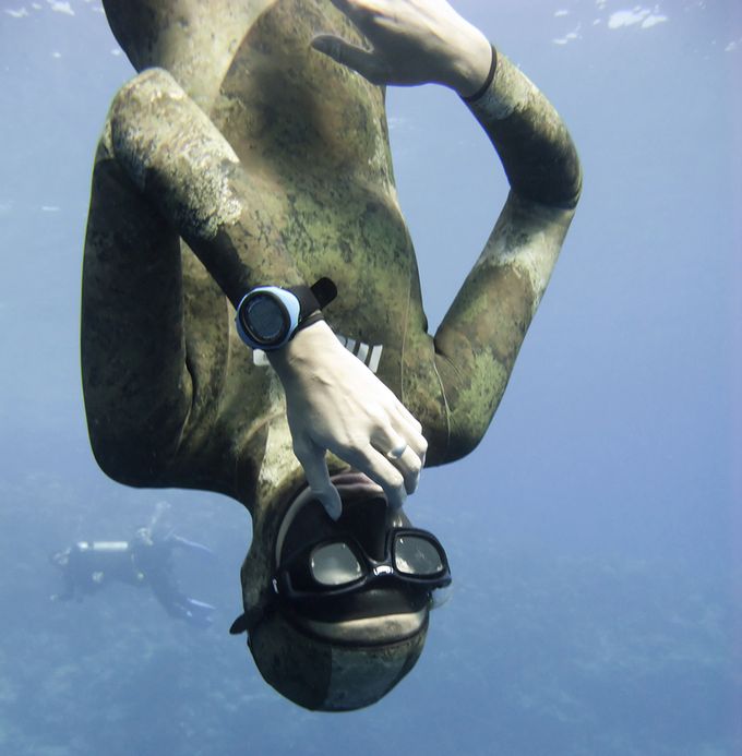 Freediver equalizing pressure while moving down. Meanwhile Blue Hole divers are watching him.