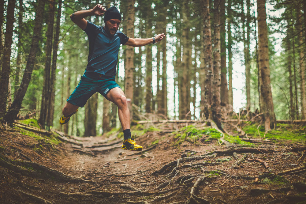 Trail-running-essential-guide-for-beginners---trail-runner-jumping-over-roots