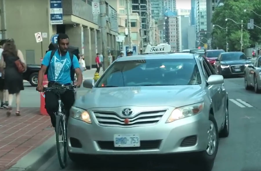 The taxi appears to swerve at the cyclist  - Photo: YouTube / Roman Atwood