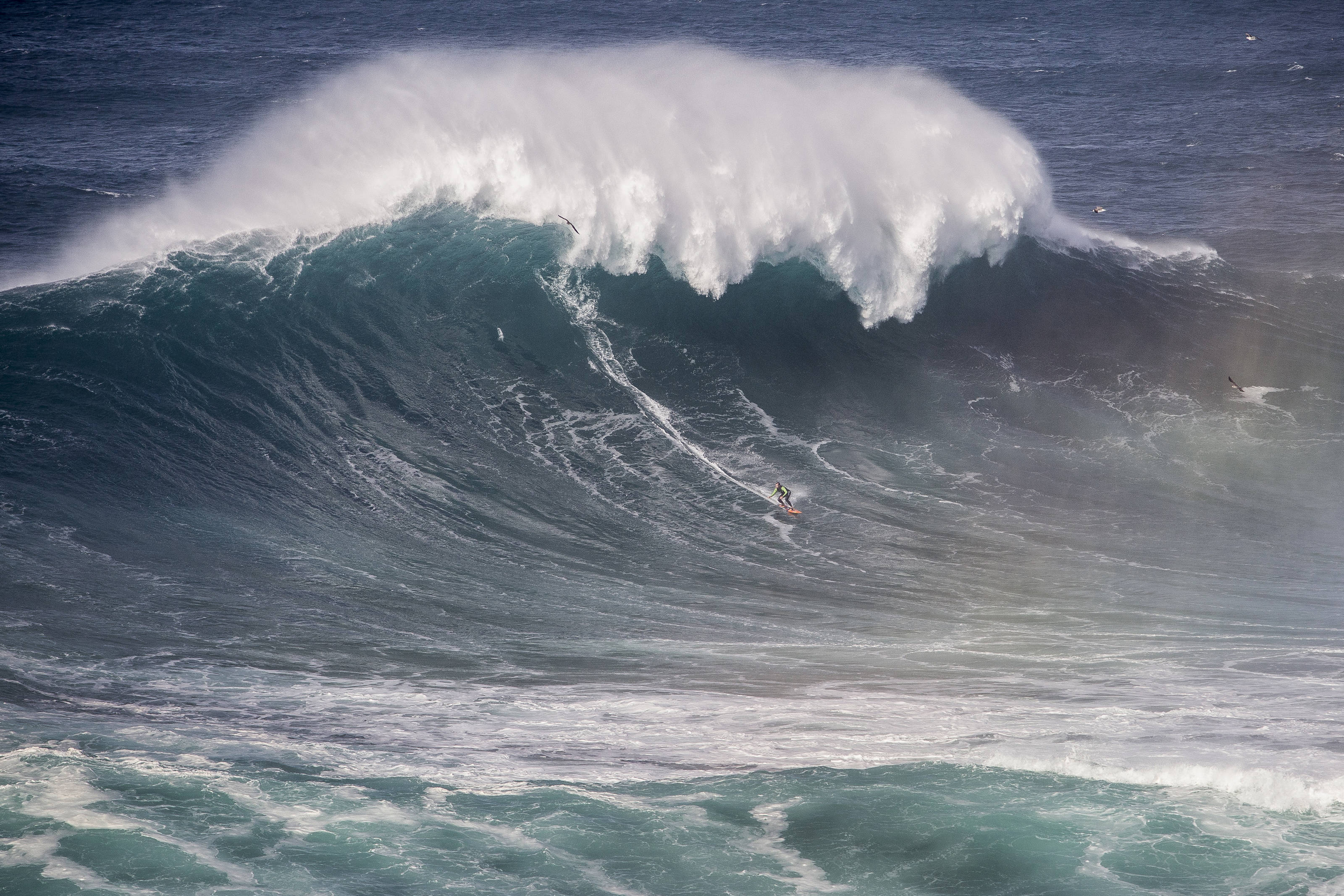 Spot the surfer... Carlos Burle takes on a monster wave - Photo: Hugo Silva / Red Bull Content Pool