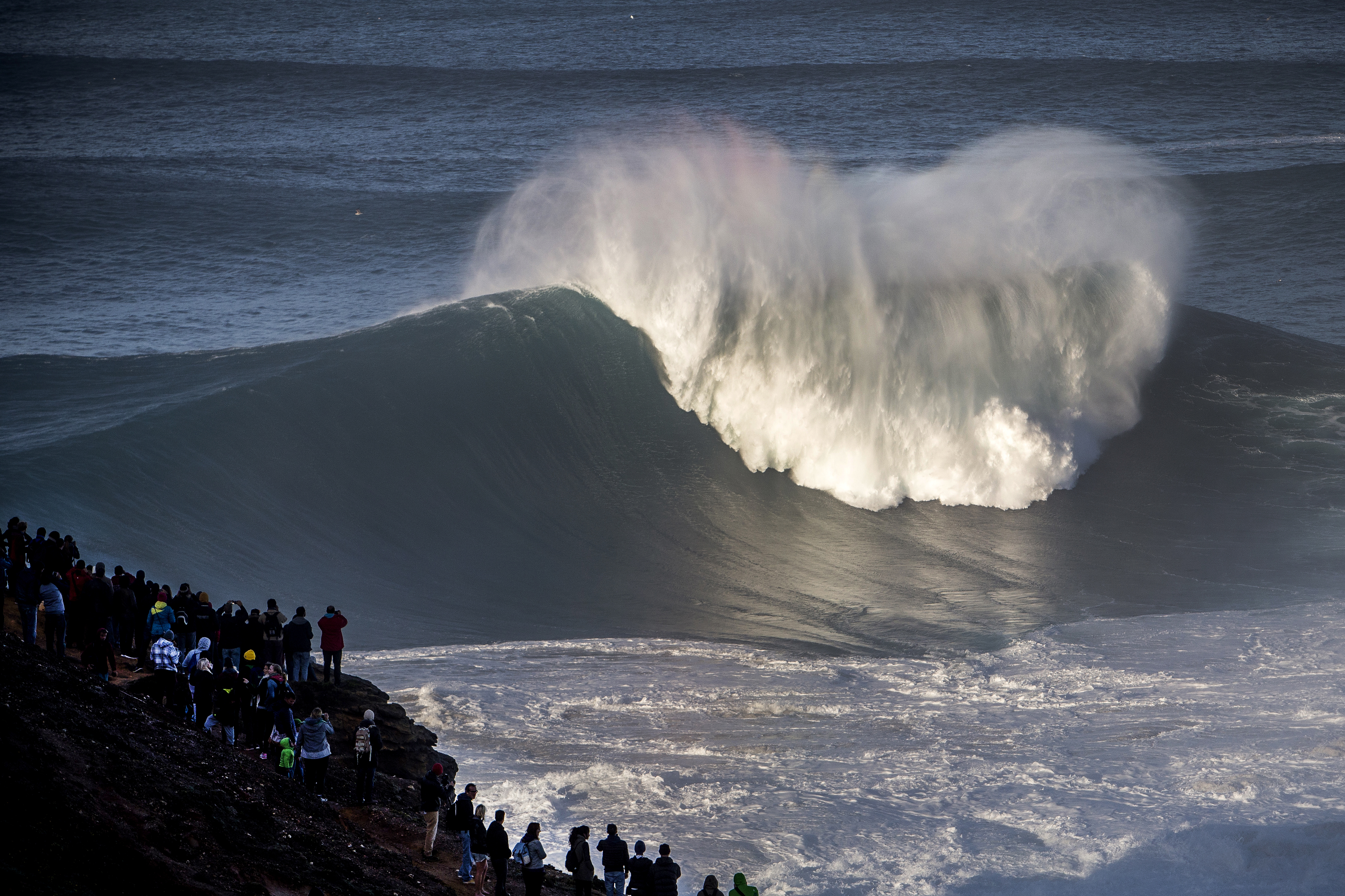 Giant waves crash in at Nazareé as spectators watch on in awe from the nearby church - Photo: Hugo Silva / Red Bull Content Pool