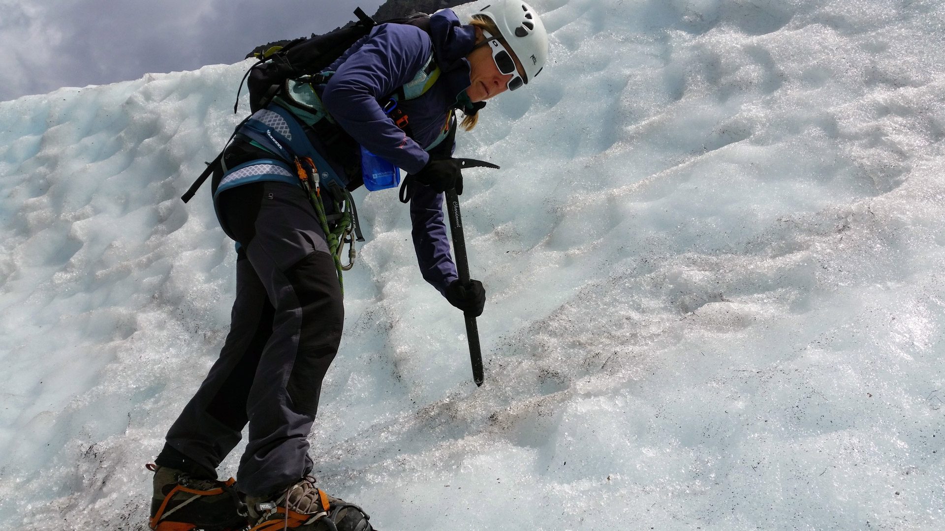 Abi learning to safely manoeuvre on a steep wall of ice with crampons and ice axe