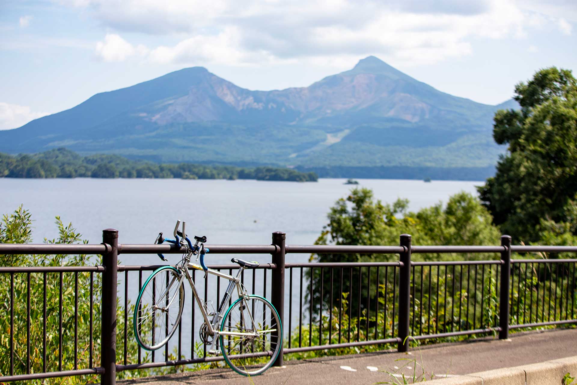 Bike resting on a fence next to Lake Hibara behinf Mound Bandai