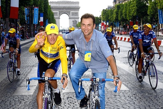 Cyclist Lance Armstrong rides alongside team manager, Johan Bruyneel