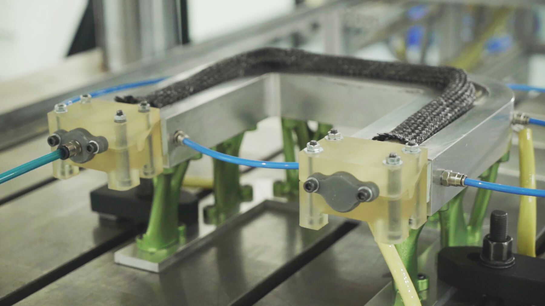 Amber fixtures printed in Formlabs High Temp Resin installed in a production machine with pneumatic lines attached