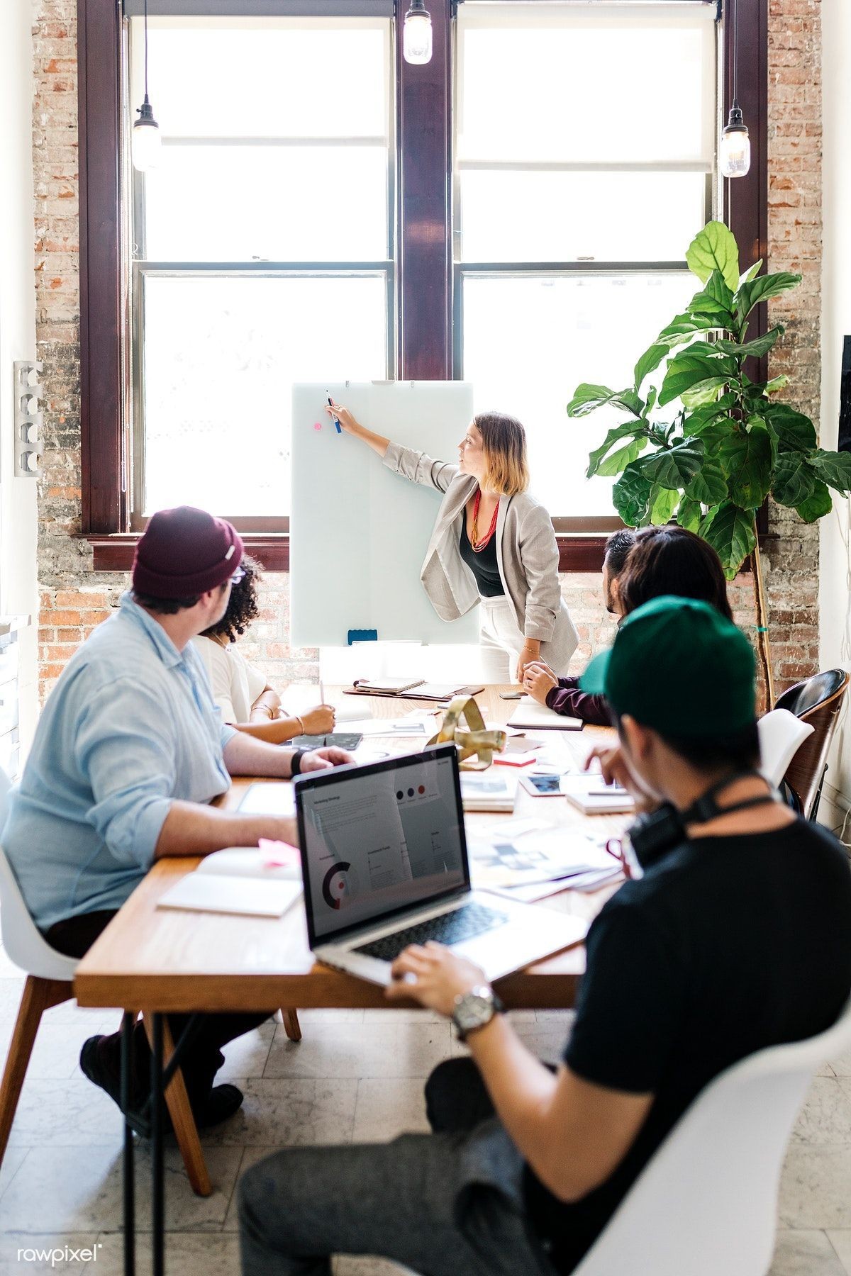 Consultant presenting at a whiteboard to a full table
