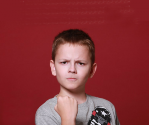 Agressive boy on red background