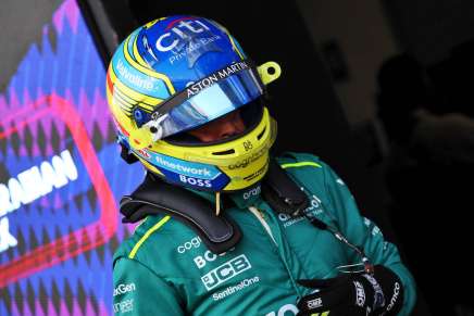 Fernando Alonso cammina nei box con la tuta dell'Aston Martin