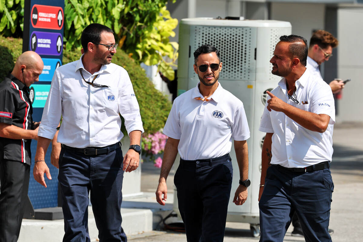 Vitantonio Liuzzi insieme ad altri due steward della FIA cammina nel paddock