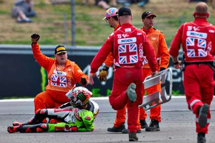 Marco Bezzecchi dolorante nella ghiaia a Silverstone dopo l'incidente con Morbidelli