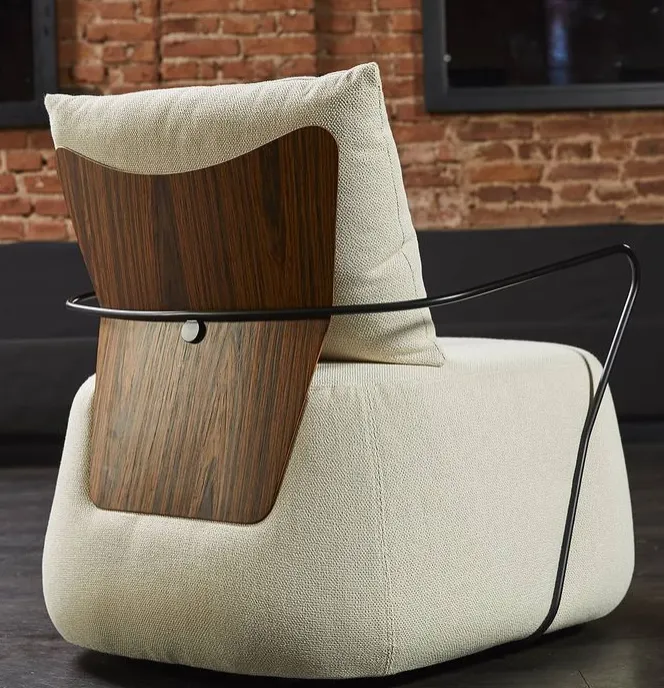 Na foto, é possível ver a poltrona Loreh. Ao fundo, dá para distinguir uma paredes de tijolos vermelhos