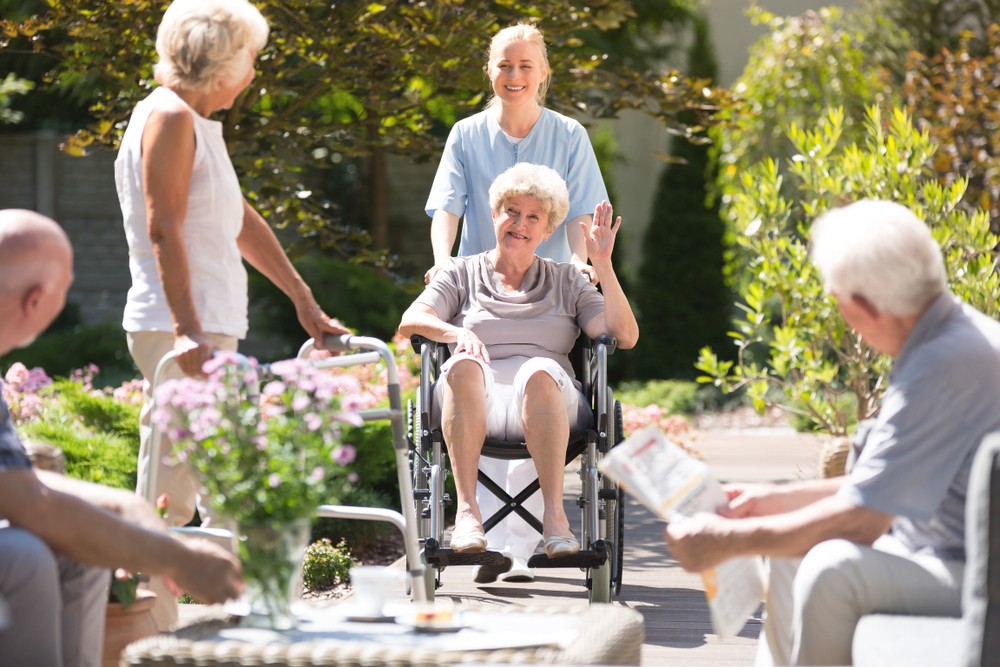 Seniors relaxing in sunny assisted living garden