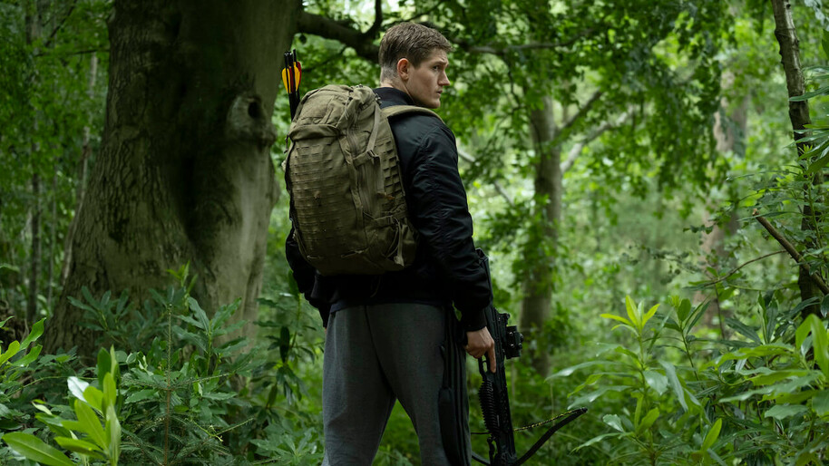 man in the woods with a crossbow and arrows