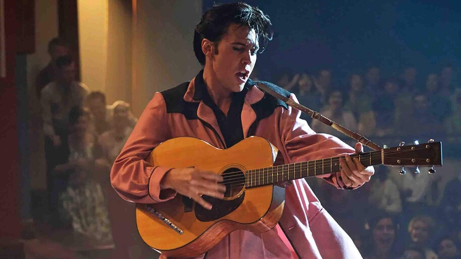 Austin Butler as Elvis playing guitar on stage