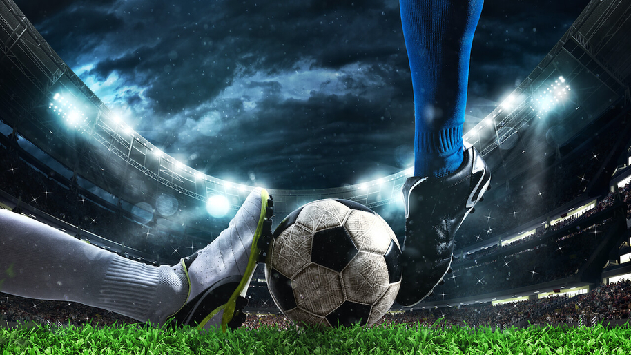 image of two football players feet kicking a football