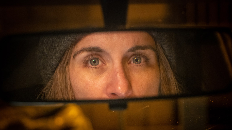 vicky mclure's eyes reflected in rearview mirror