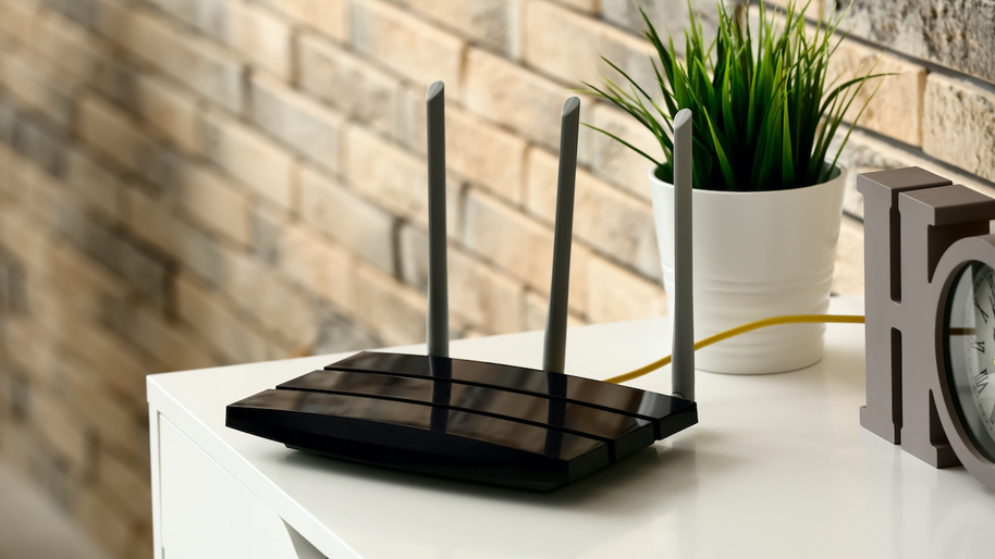 Wi-fi router on table near brick wall