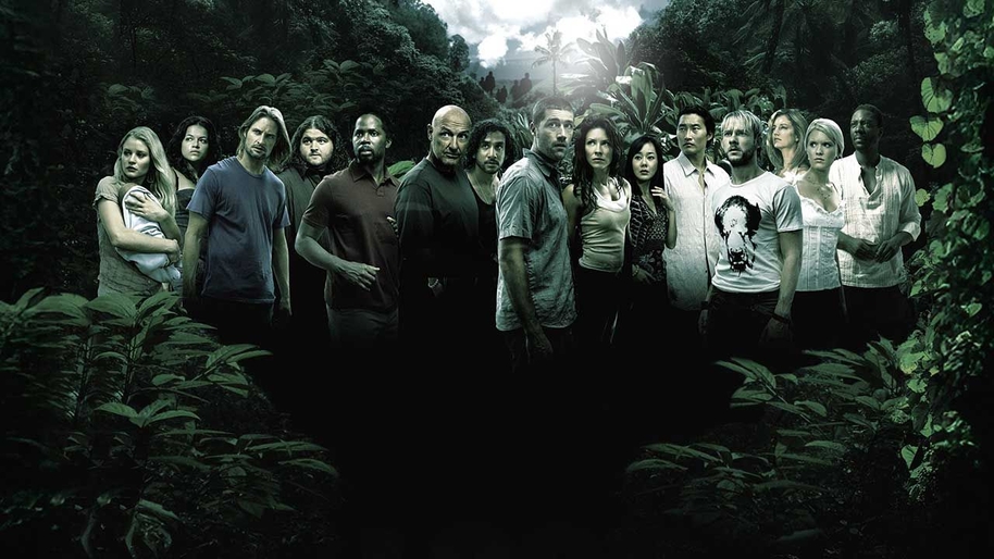 A group of men, women and a baby stood in what looks like a forest staring into the camera