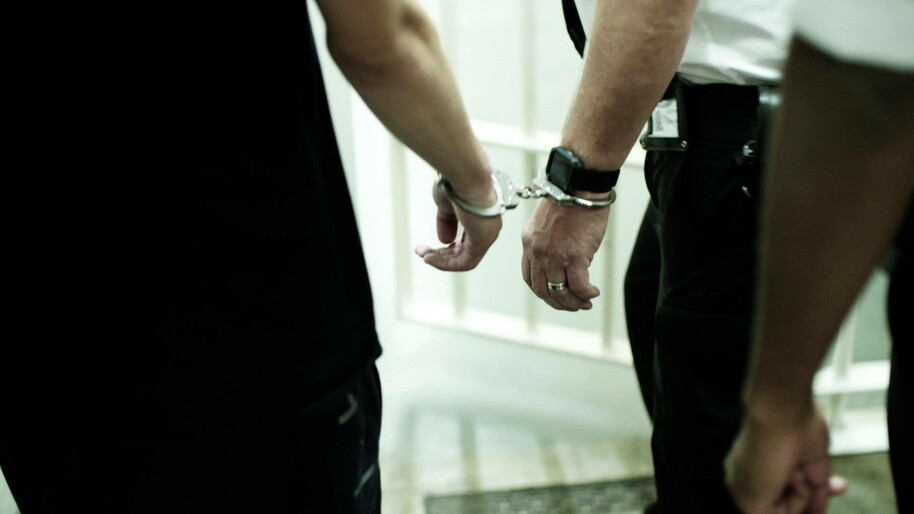 man in handcuffs with police