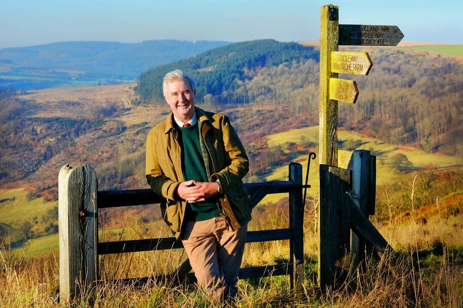 man leaning on a fence against yorkshire landscape