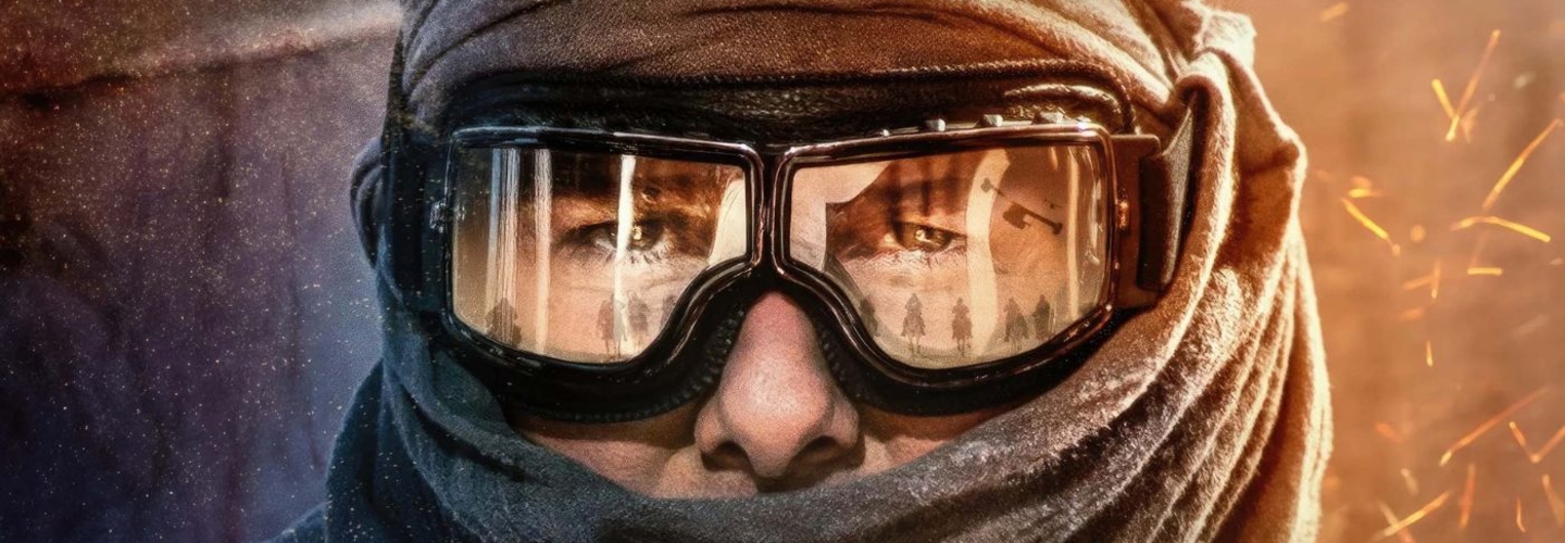 A man with goggles and a scarf around his neck with the reflection of solders in the goggles
