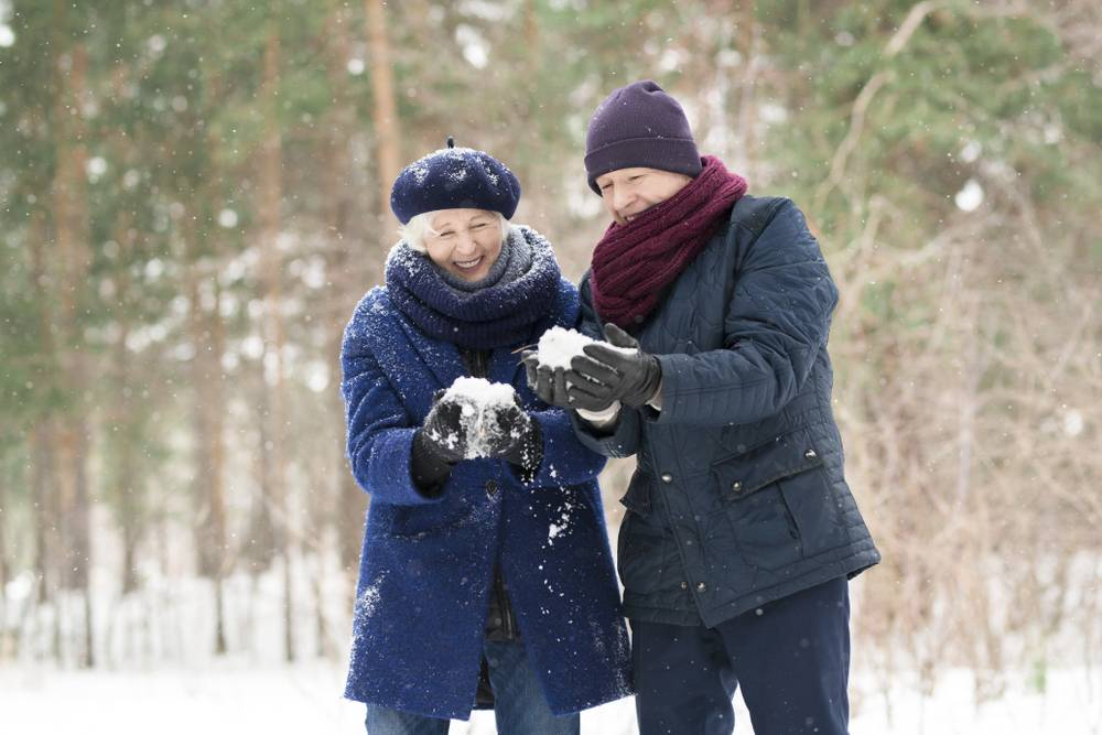 a senior couple playing in the snow
