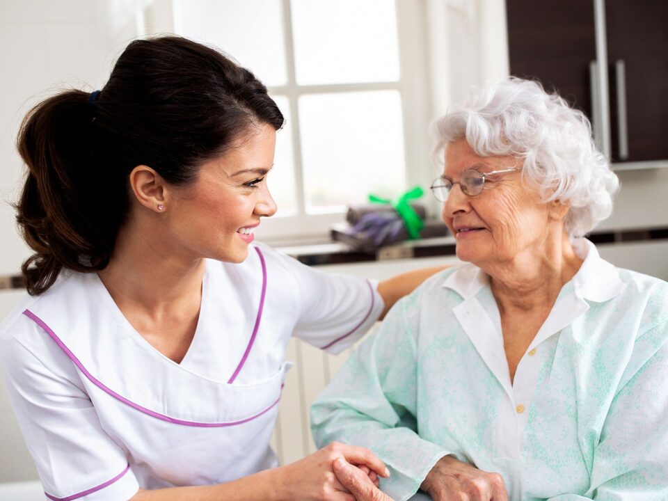 Senior woman speaking with caregiver or nurse.