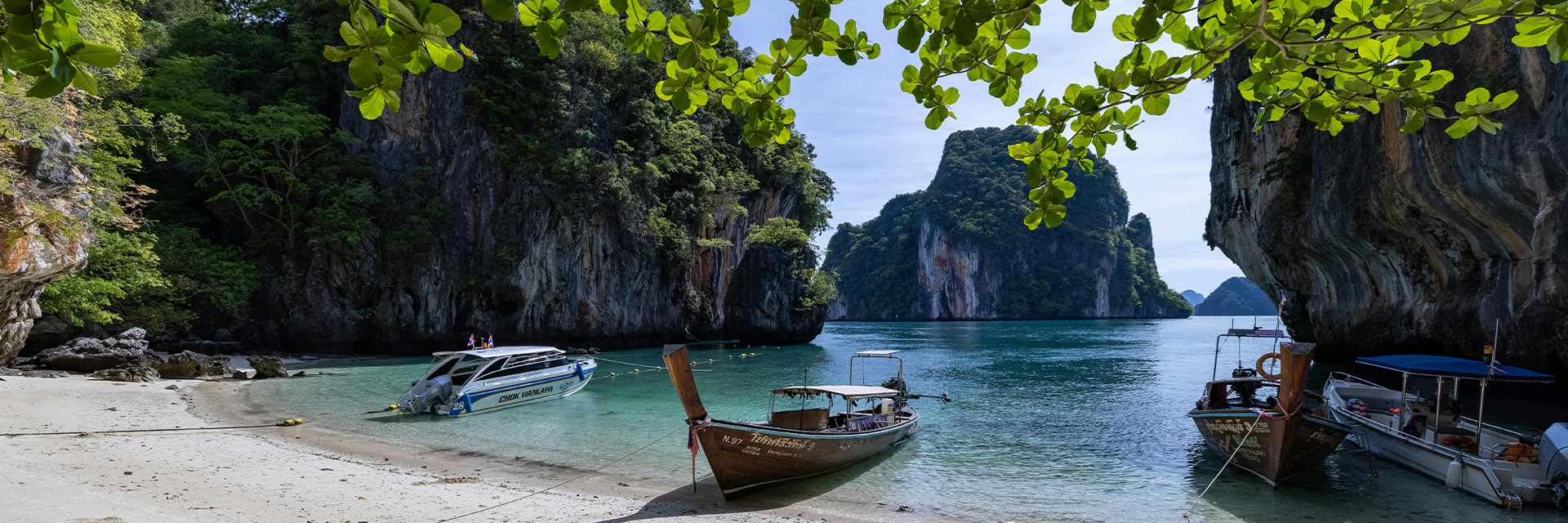 Modern luxury villa in Thailand featuring a sunset-lit infinity pool above coral-blue ocean.