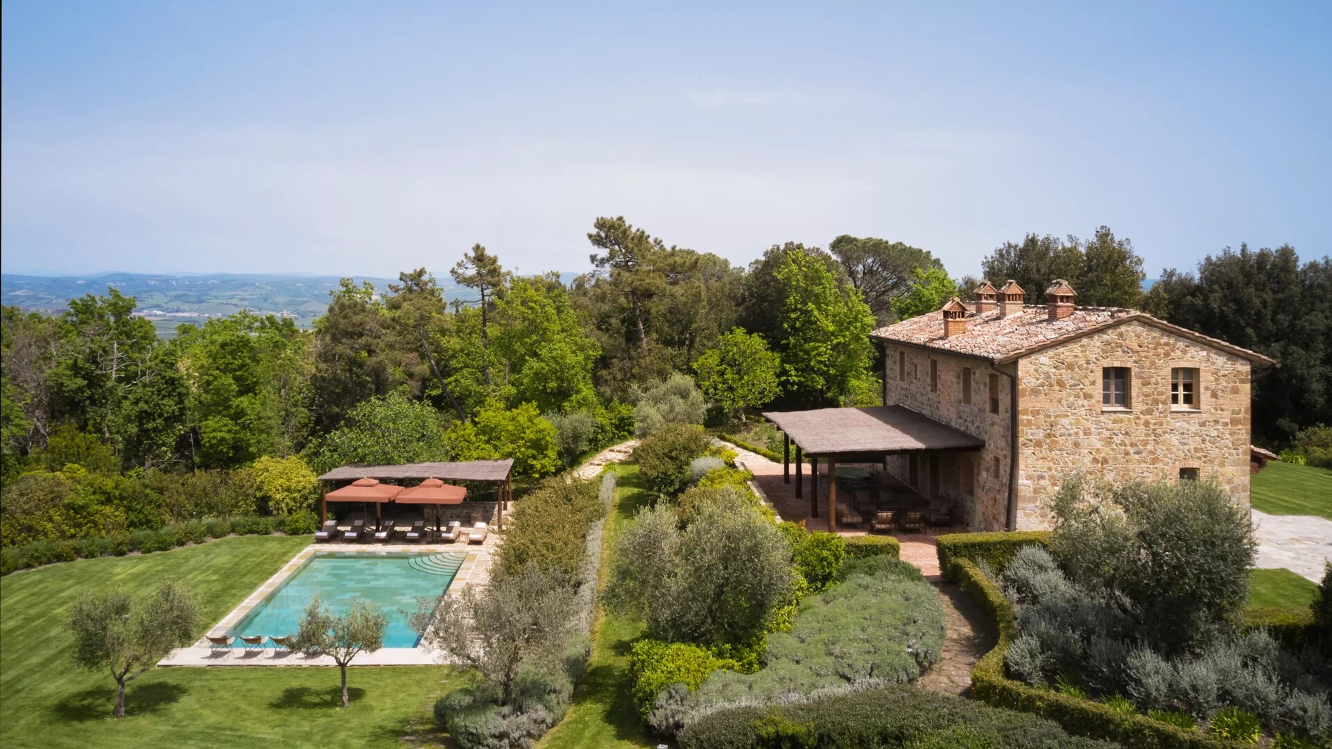 Luxury villa in Italy overlooking terraced vineyards and golden sunset hills.