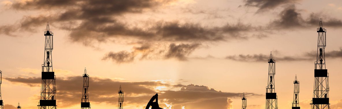 Oil derrick against yellow sky