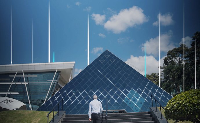 Man standing in front of glass pyramid