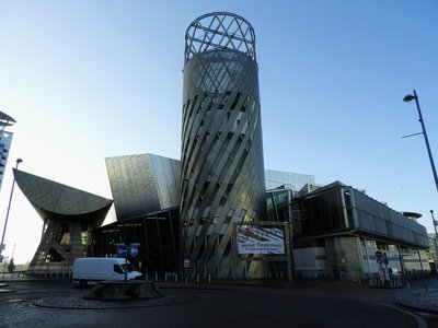 The Lowry arts centre at Salford Quays with its metallic tower and angular facade under a blue sky