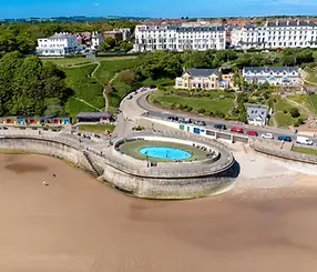 Aerial view of Filey's sandy beach, curved promenade and seafront gardens