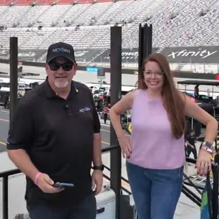 At the track beside the pink #03 car.