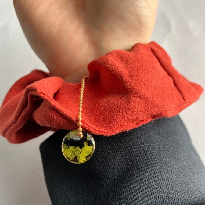 【ハンドメイド】チャーム付きレッドオレンジ色シュシュ　アフリカ布を使った黄色の丸パーツチャーム🟡