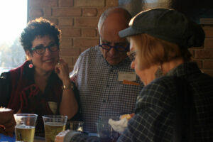 Three seniors drinking wine from plastic cups at an event