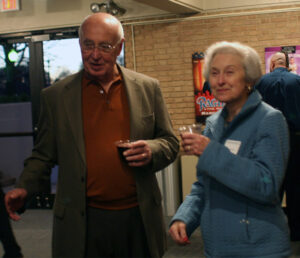 A senior woman and a senior man holding plastic cups of wine