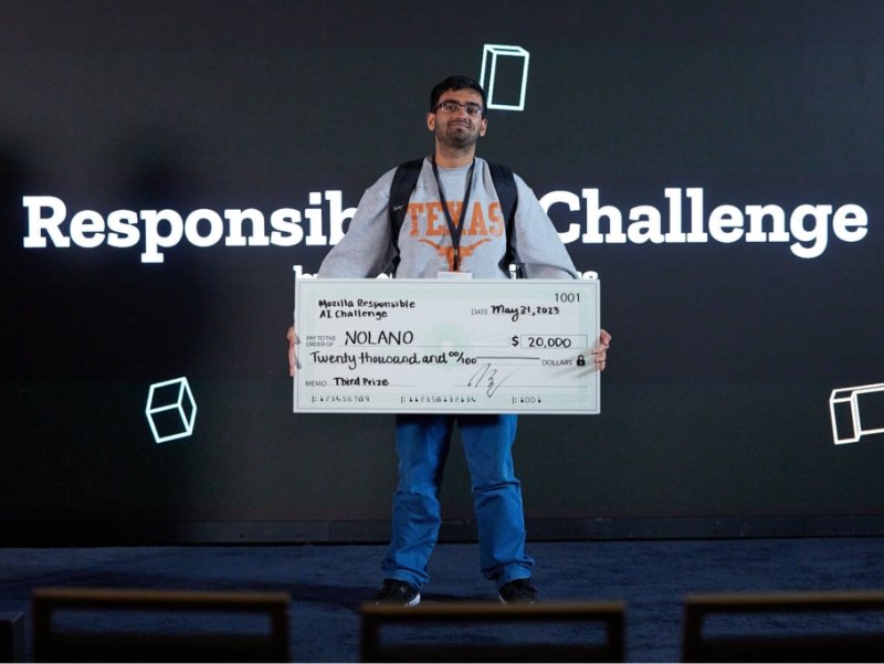 One person holding a giant cheque for $20,000