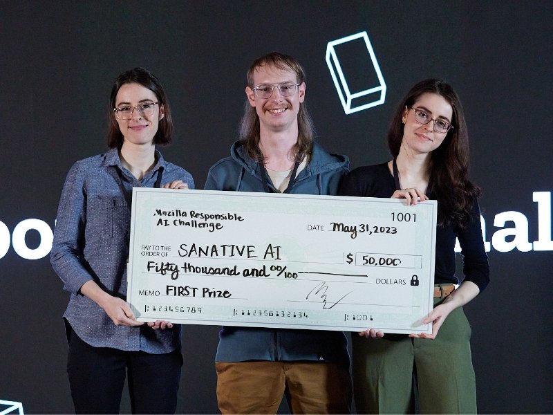 Three people holding a giant cheque for $50,000